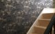 Staircase wall papered in black and gold patterned wallpaper