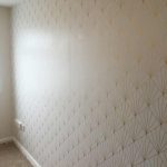 Wall covered in white wallpaper with a gold geometric pattern.