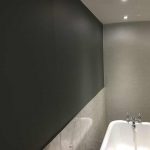 Bathroom showing a free standing bath with a dark grey feature wall along side the bath.