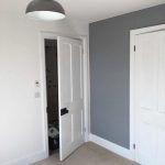 Bedroom wall with entrance door and a white wardrobe door.