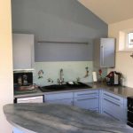 Kitchen area with blue wall to match the units and Morning Light paint on other walls and ceiling.