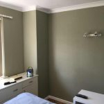 Bedroom with Overty Olive walls and white ceiling.